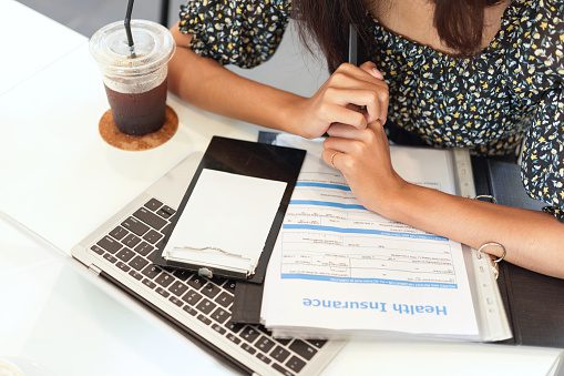 A woman looking over health insurance forms.