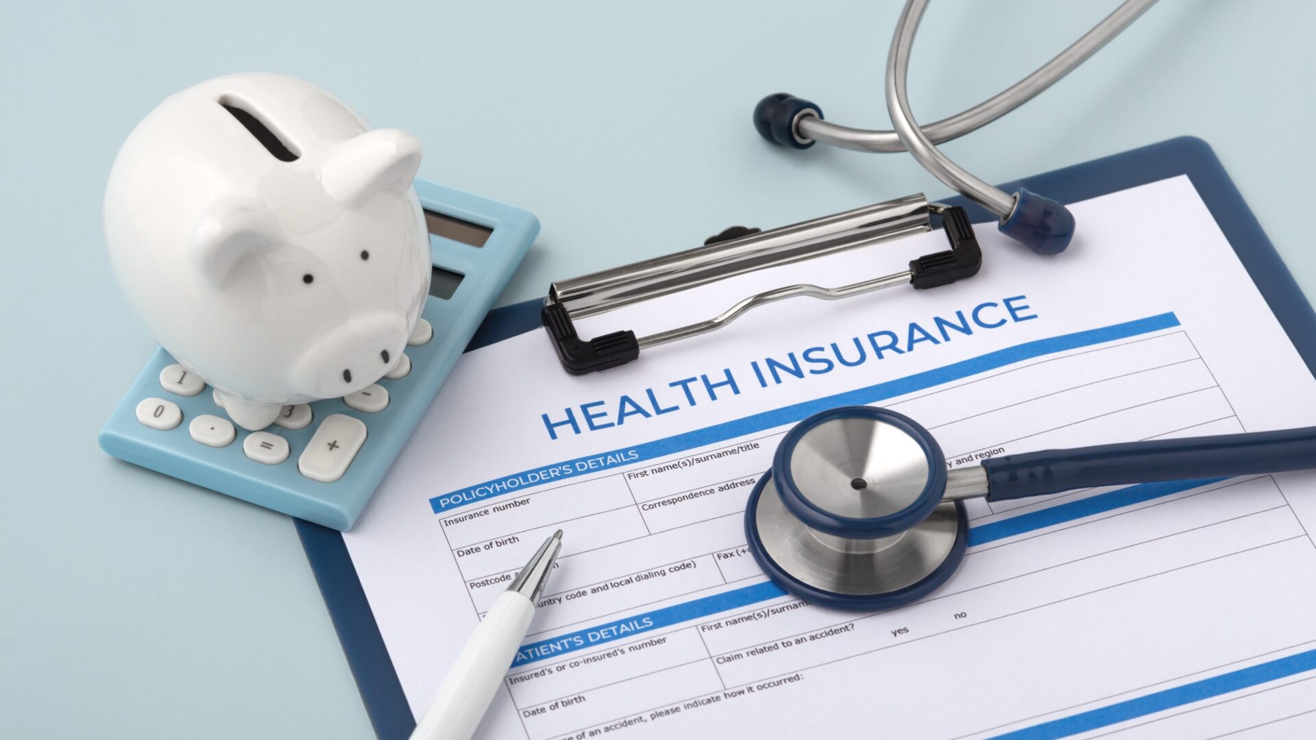 Health insurance with piggy bank on calculator on blue background.