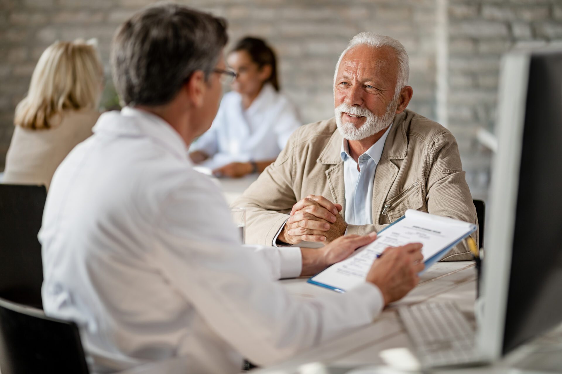 A senior man discusses Medicare options with an advisor.